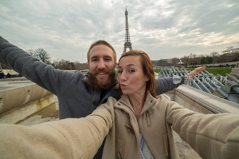 一对年轻夫妇在巴黎埃菲尔铁塔自拍