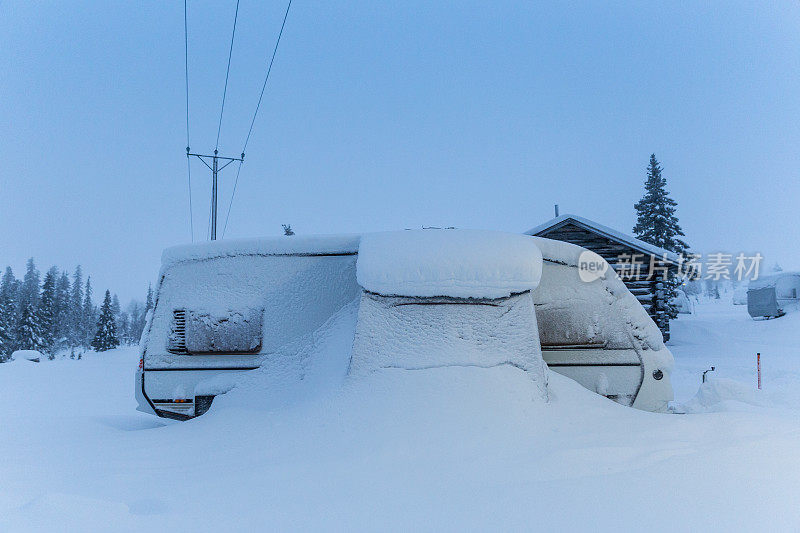 冬季埋在雪中的移动大篷车露营车