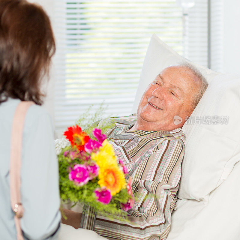 带着花的访客和躺在病床上的老人