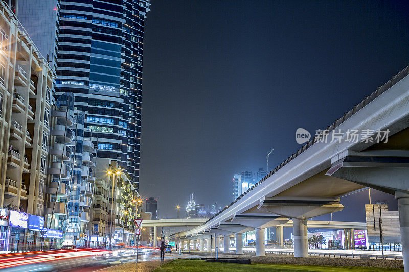 迪拜繁忙的街道，地铁高架线，办公楼的夜晚