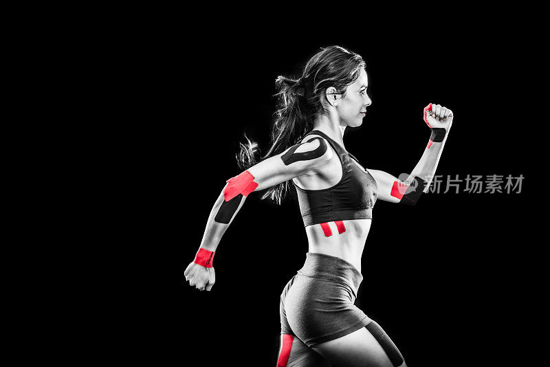 女跑步者与运动机能学胶带在她的关节
