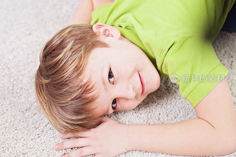 小男孩在地毯上。