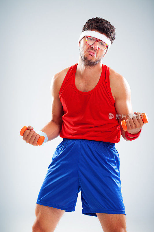 不开心的运动员用橙色的小砝码锻炼