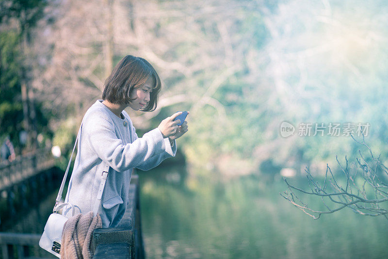 年轻女子在桥上拍照