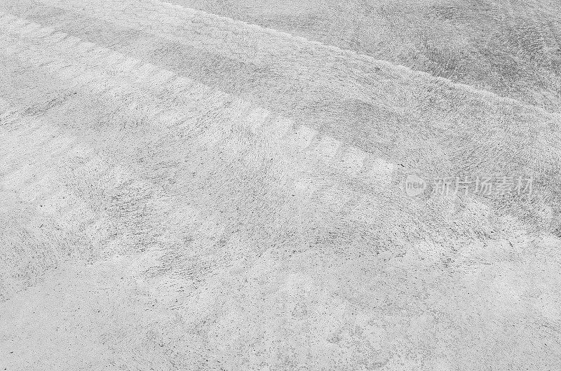 特写表面混凝土地板与轮胎痕迹纹理背景在黑白色调
