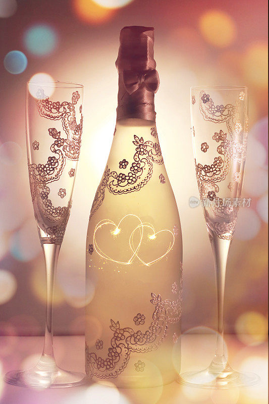 一瓶香槟和两个装饰着两颗相互交织的心的玻璃杯