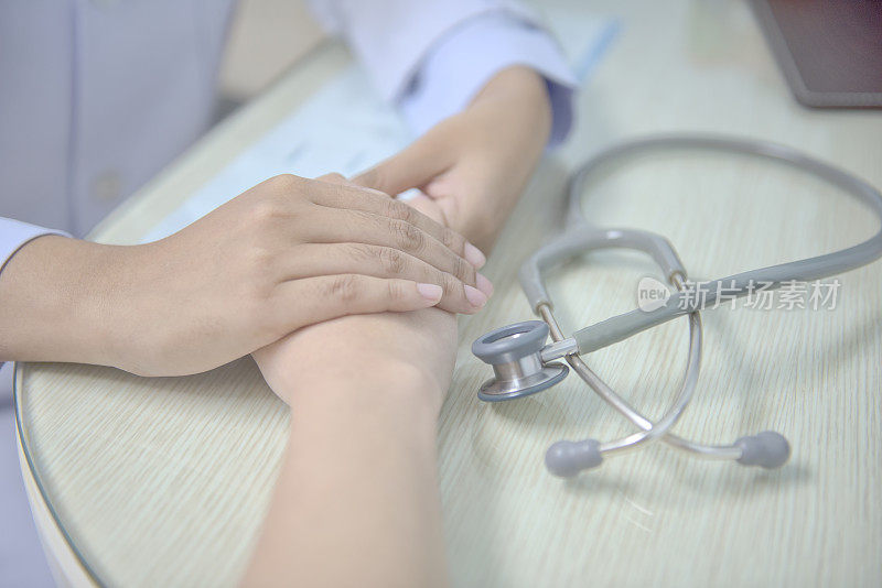 柔焦，医生握着病人的手，以寻求安慰。并确保治疗计划。