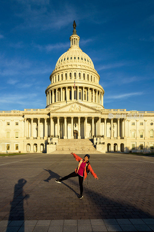 张开双臂，游客在国会大厦前享受日出