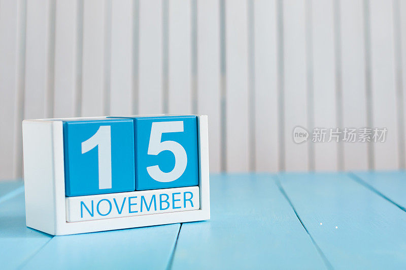 11月15日。11月15日的图片，蓝色背景的木制彩色日历。秋季的一天。文本空白