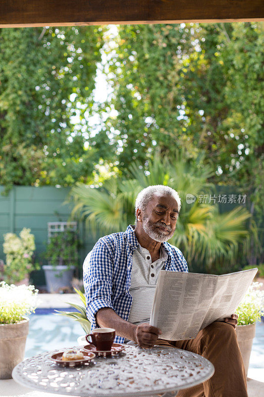 老人在餐桌上看报纸