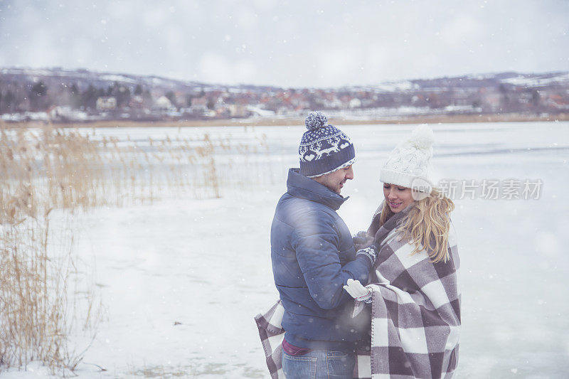 在冬天，一对夫妇在温暖的格子毯子里拥抱