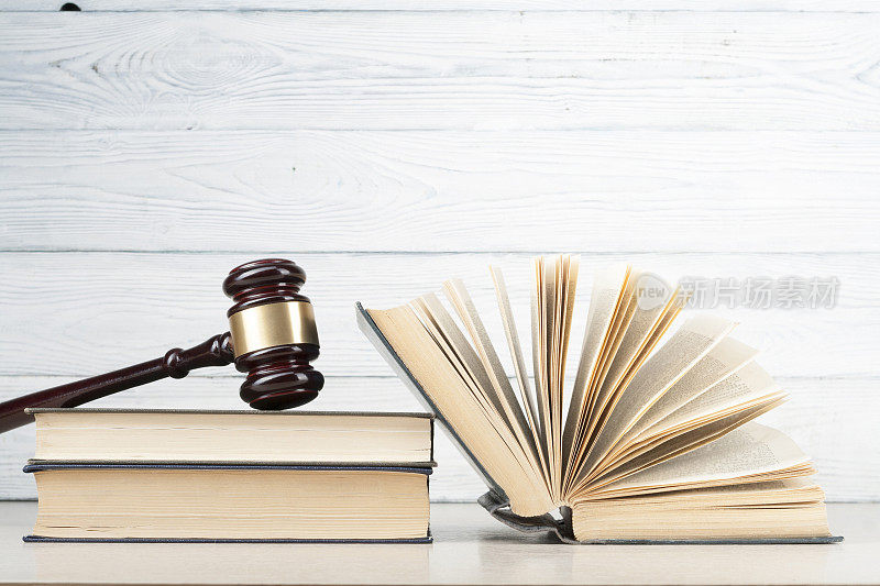 法律的概念。在法庭或执法办公室的桌子上放着书和法庭的木槌。