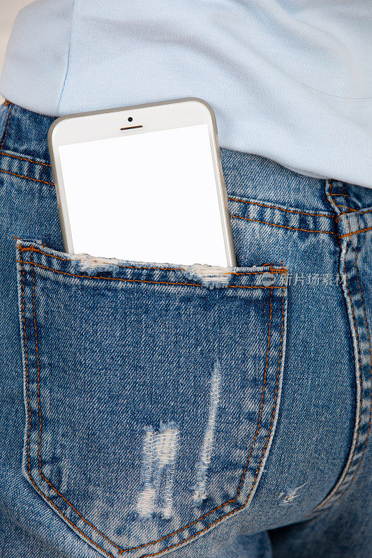 近距离的智能手机与空白屏幕在牛仔裤口袋。