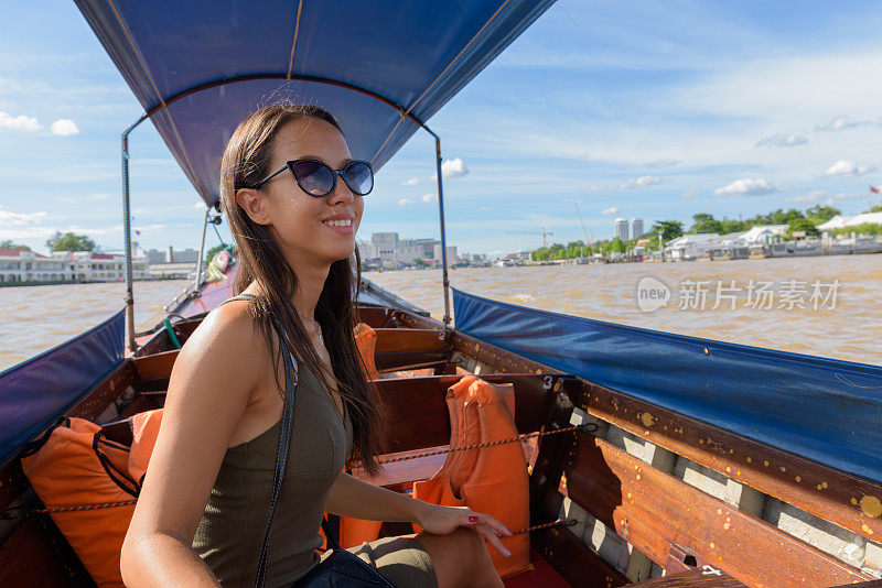 年轻美丽的多民族旅游妇女的肖像乘坐泰国出租车船，探索泰国曼谷的城市