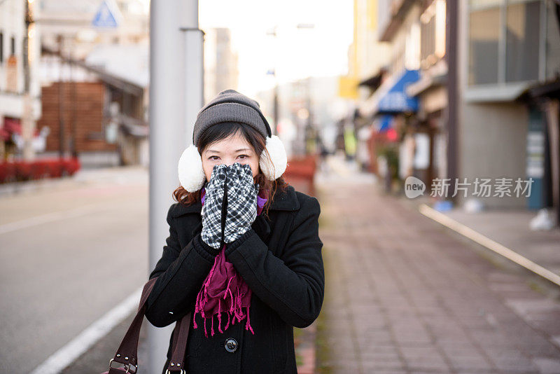 年轻的女士在秋天的街上感到寒冷