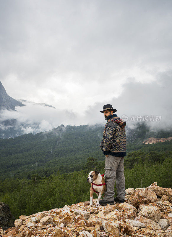 带着狗在山上徒步旅行的人