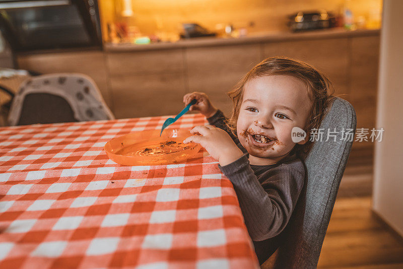 蹒跚学步的孩子吃面包和巧克力黄油