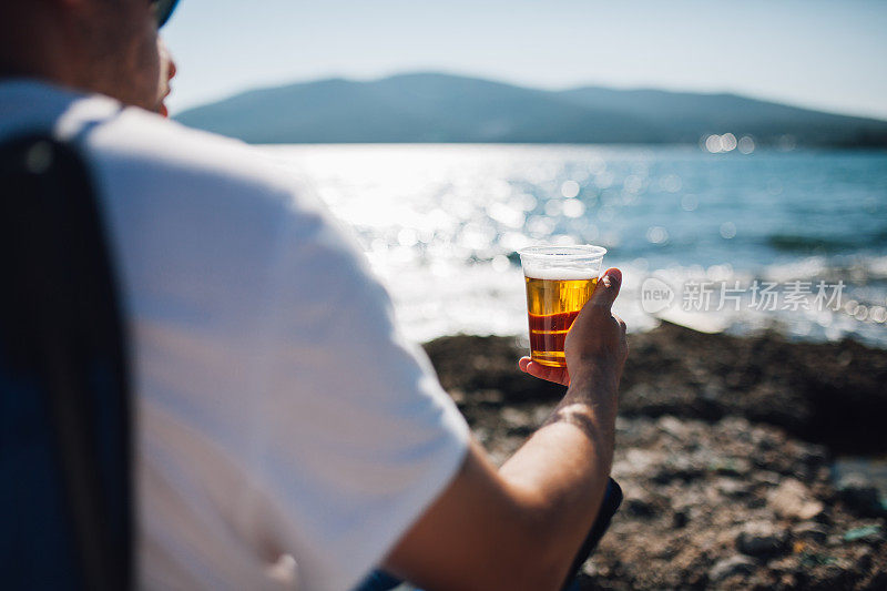 在海滩上喝啤酒的男人