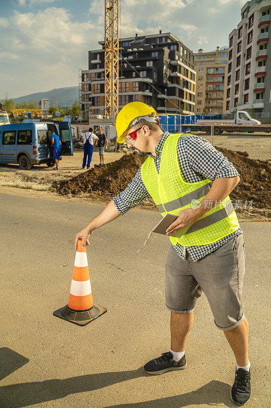 手工工人在建筑工地放置安全交通锥