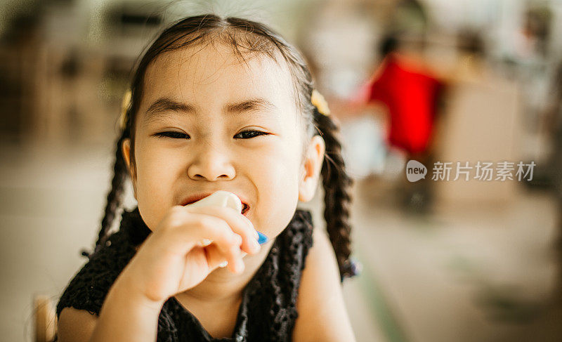 亚洲可爱的小女孩吃糖果