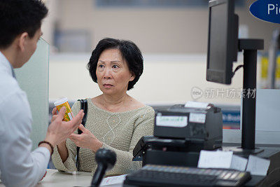 亚洲女性接受建议从男性药剂师库存照片