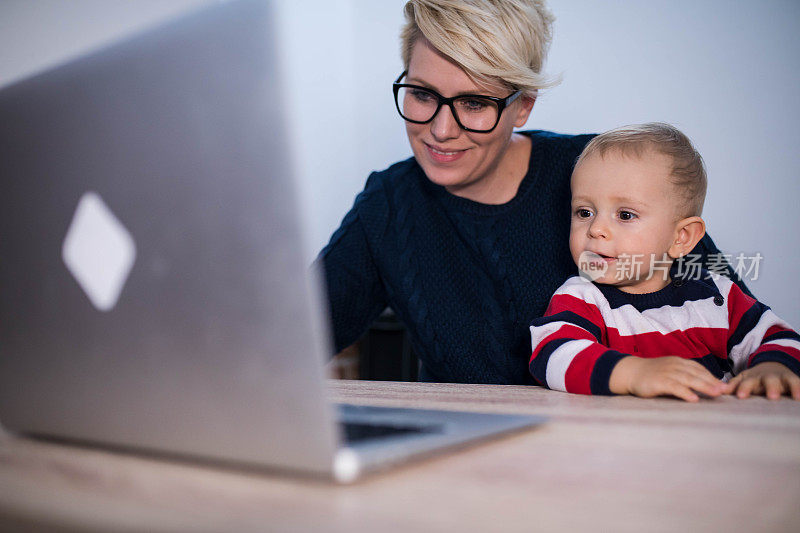 商业，母亲，多任务，家庭和人的概念-快乐微笑的商业女性与婴儿和笔记本电脑在办公室工作