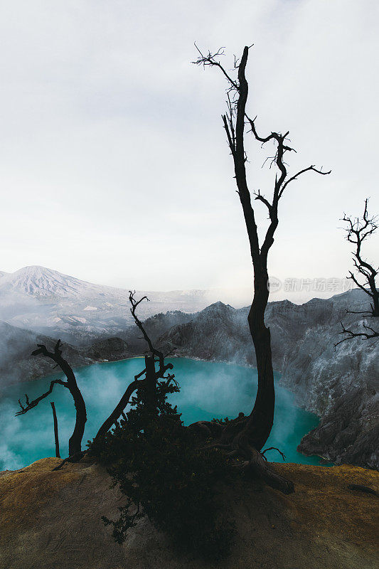 印度尼西亚东爪哇的伊真火山火山口的绿松石色湖泊，山脉和硫磺蒸汽的戏剧性景色