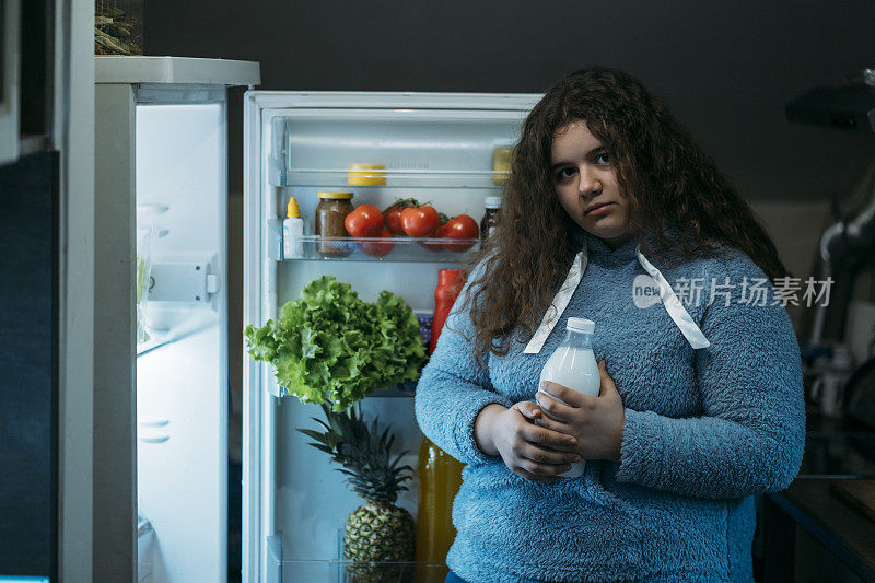 十几岁的女孩晚上偷偷从冰箱里喝东西