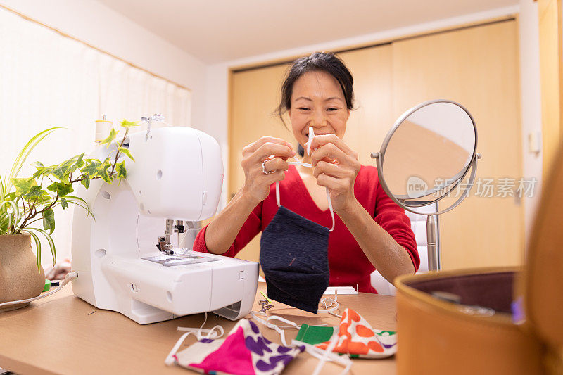 一名日本妇女在家里制作面具