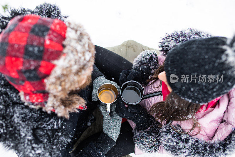 一对夫妇在雪地里喝茶，还可以俯瞰风景