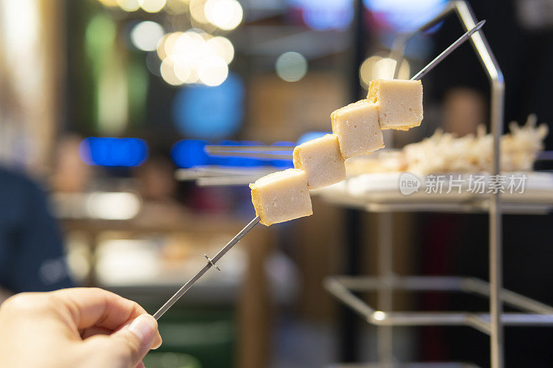 特写的鱼豆腐串准备烧烤在前面的食品货架在餐厅