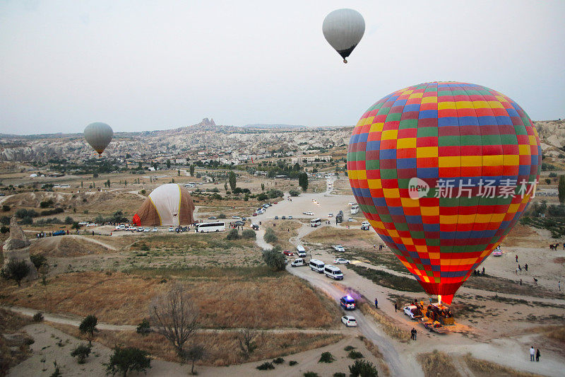 热气球飞过卡帕多西亚山谷，土耳其的旅游目的地