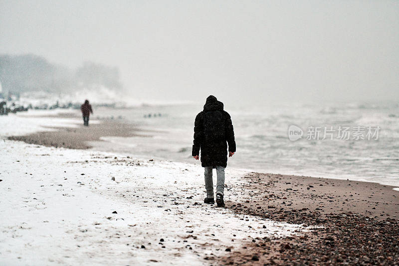 一个悲伤的人在冬天沿着大海走。抑郁,分手