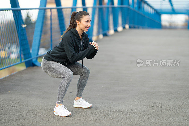 一个年轻女子在河边做下蹲练习