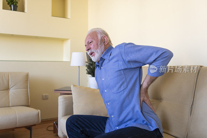 年长的大胡子男子正在与背部的疼痛作斗争。