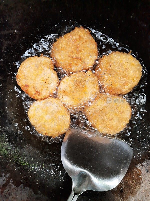 用铁锅煎虾饼。