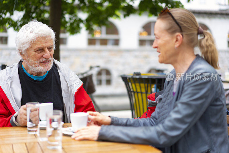 帕金森病患者与妻子在餐厅喝咖啡的肖像。