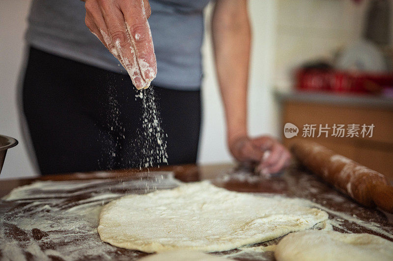 面包师用擀面杖揉面团