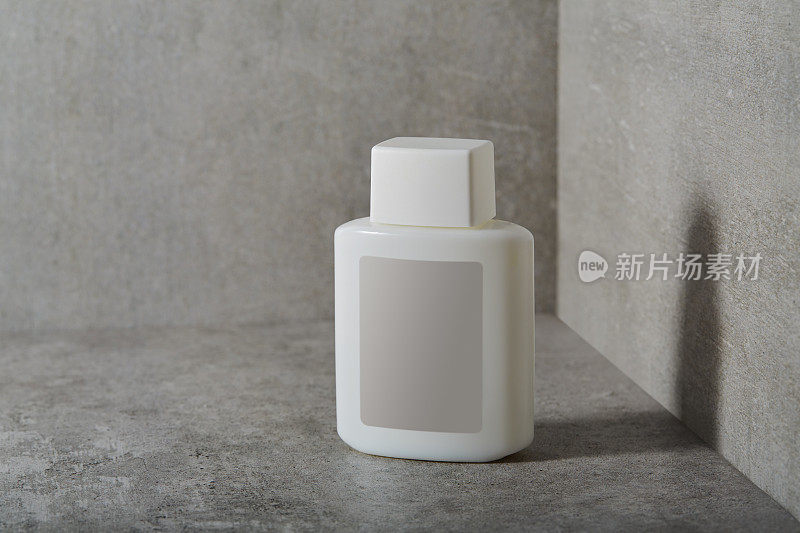 面部或身体护理化妆品瓶子，混凝土背景上有空白标签