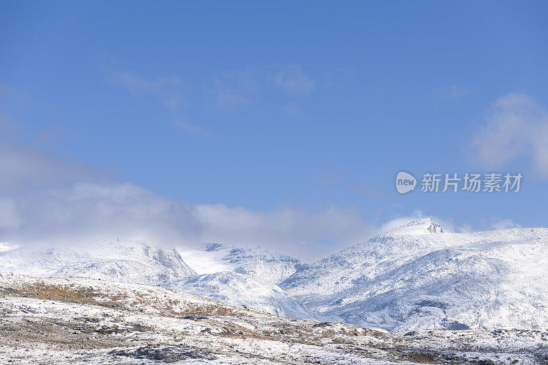 在挪威的高山上，沿着布满岩石的徒步路线，秋天的第一场雪