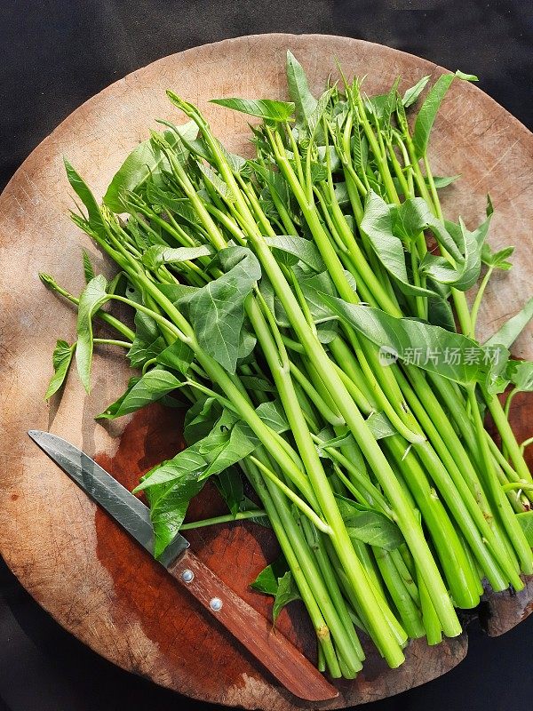 在切菜板上切牵牛花蔬菜-准备食物。