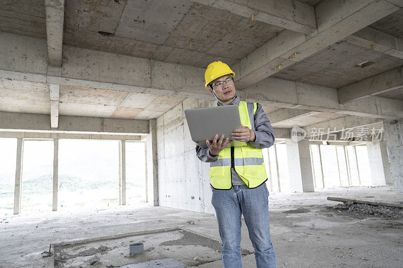 一个亚洲男性工程师在一个未完工的建筑工地