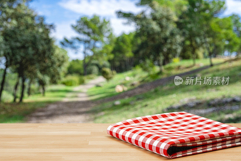 折叠的野餐毯子在桌子上和树林的背景