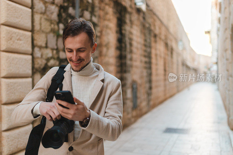 年轻男性游客在游览杜布罗夫尼克老城区时使用手机