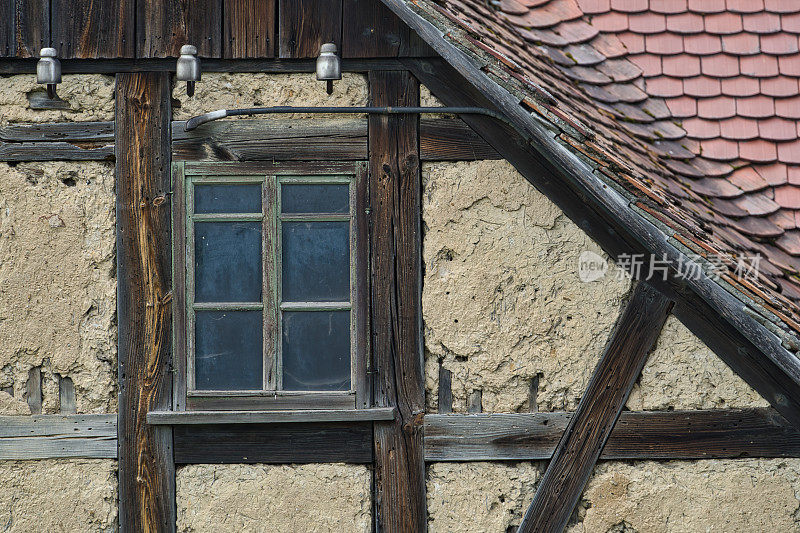 带窗户的老木结构房子的墙。