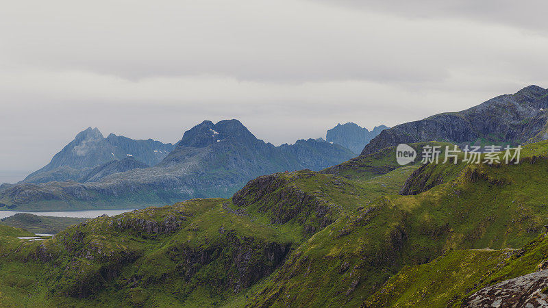 远处的红山小屋被罗弗敦群岛的风景优美的山脉包围