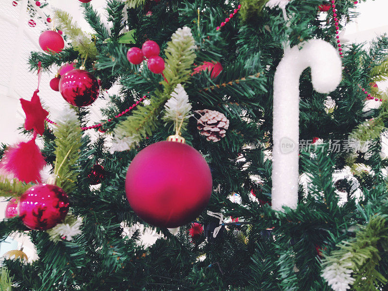 圣诞树上有装饰品、圣诞球和玩具。红白挂饰。美丽的球，明亮的浆果和球果。雪糕棒