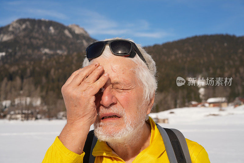 老人的肖像，帕金森病患者用雪冷却他的脸，闭上眼睛紧张，在斯洛文尼亚越野滑雪