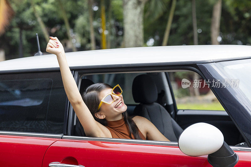 年轻女子享受着她的旅行和车里的空气