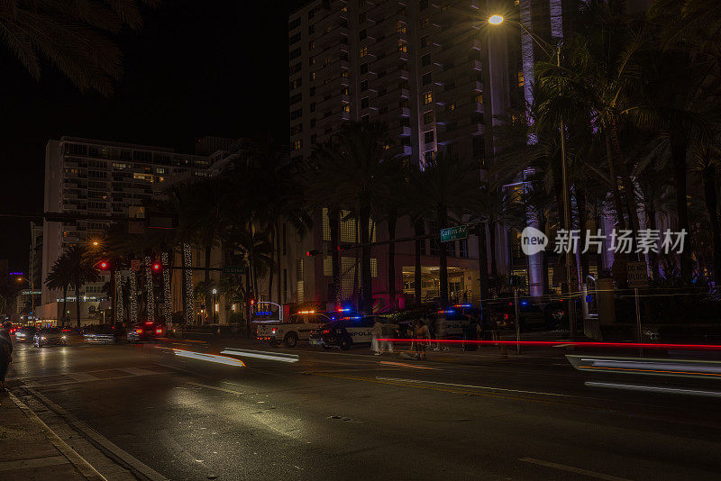 迈阿密海滩的夜景，警车和柯林斯大道上汽车的散焦光追踪器。迈阿密海滩。美国